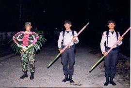 Anggota TNI / Polri membawa papan bunga dan tombak bambu runcing menuju taman pahlawan pada malam...